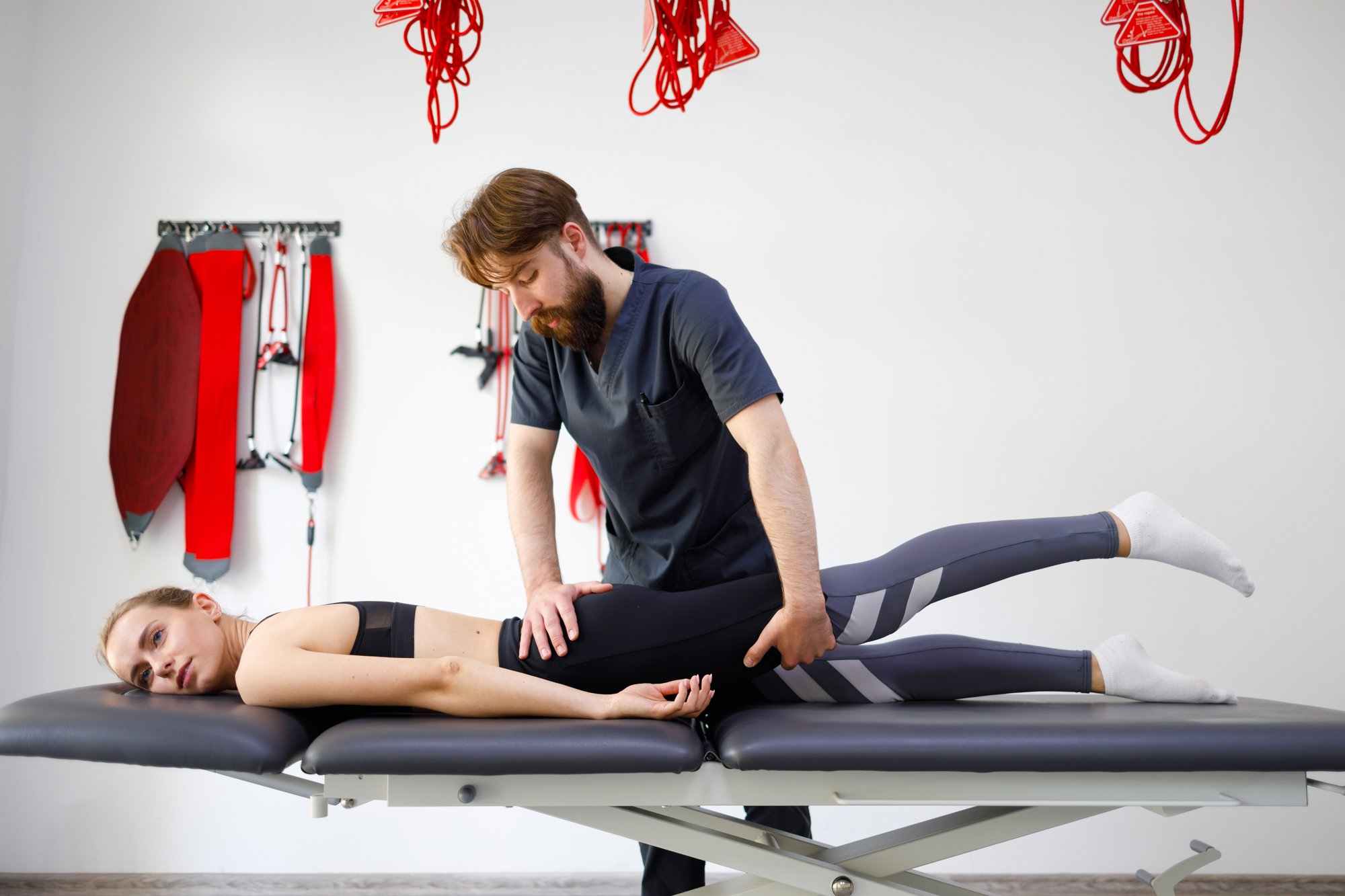 chiropractor-stretching-the-legs-and-hips-of-a-you-2024-10-21-09-44-58-utc